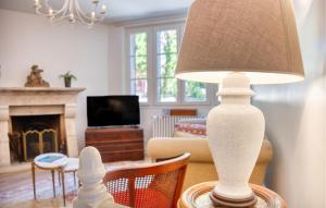 a white lamp sitting on a table in a living room at Charmante Maison Avec Piscine in Savignac-les-Églises