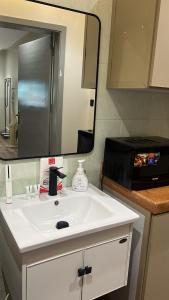 a bathroom sink with a mirror and a microwave at Quite and cozy studio in Riyadh