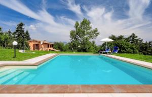 a swimming pool with two chairs and a house at Lovely Home In Valfornace in Pievebovigliana