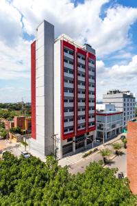 a tall red and white building in a city at GHL Style Barrancabermeja in Barrancabermeja