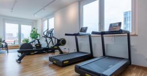 a gym with several exercise bikes in a room at Homely! Skyview 2-Room Apartment, Airport, Fair, Rooftop, Gym! in Frankfurt/Main