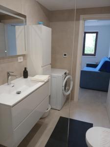 Un baño con inodoro, lavabo y espejo. en Lara - private parking and garden, en Razvala 31 fotos más