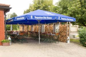 a table and chairs under a blue umbrella at Dorfschänke Kreuz in Landensberg