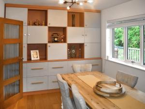 Un comedor con mesa y sillas de madera. en Bracken Lea, en Barbrook