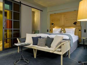 a bedroom with a bed and a couch and a table at 25hours Hotel Altes Hafenamt in Hamburg