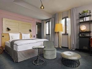 a bedroom with a large bed and a chair at 25hours Hotel Altes Hafenamt in Hamburg