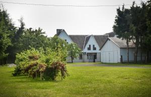 a large white house with a grass yard at Jöekalda Accommodation in Pulli