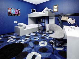 a blue room with a bed and a desk and a chair at 25hours Hotel The Trip in Frankfurt/Main