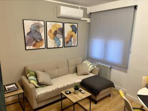 sala de estar con sofá y 4 pinturas en la pared en imak barrio del AVE, en Zaragoza