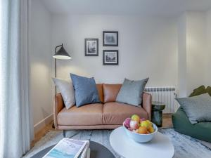 a living room with a couch and a bowl of fruit on a table at Sea Beet - Uk49245 in Whitstable