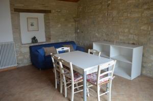 a white table and chairs in a room with a blue couch at Urbania, Arte e Natura in Urbania