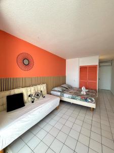 ル・ディアマンにあるSuite Sabi Vue Merのオレンジ色の壁の客室内のベッド2台 +15枚の写真