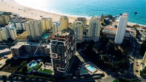 an aerial view of a beach with buildings and the ocean at Ed Elite 3F Apartamento a 5 min a pé da Praia da Rocha com piscina e garagem in Portimão