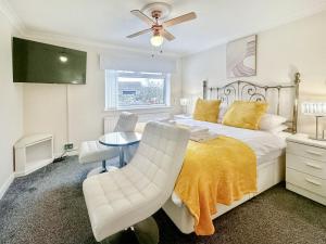 a bedroom with a bed and a table and a chair at Sunrise Villa in Clacton-on-Sea