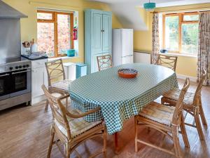 a kitchen with a table and chairs in a kitchen at Erw Goed Old Barn in Arthog