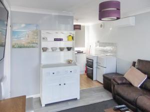 a living room with a couch and a kitchen at The Little House in Kessingland