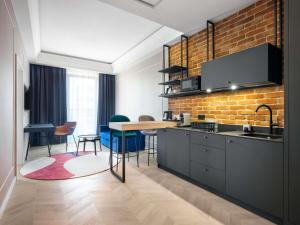a kitchen with a brick wall and a table and chairs at Mercure Krakow Fabryczna City in Krakow