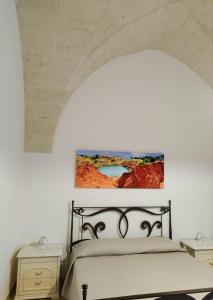 una camera da letto con un letto con un quadro sulla parete di OtrantoCasa a Otranto