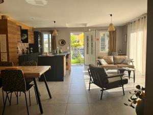 a kitchen and living room with a table and a couch at Le Saint Marin in Chatuzange-le-Goubet