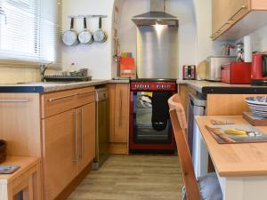 a kitchen with a stove top oven next to a counter at The Secret Garden in Windermere