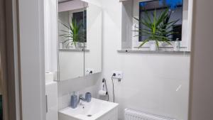 a white bathroom with a sink and a mirror at Nocleg pod dębem in Czerna +22 photos
