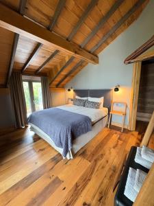 a bedroom with a large bed in a room with wooden floors at Çalıkuşu Dağ Evi in Bursa