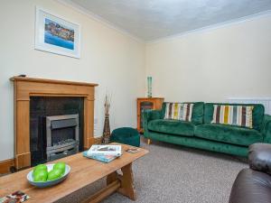 a living room with a green couch and a table at Tanglewood in Bugle