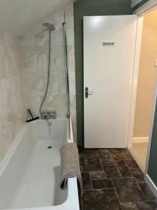 a bath tub in a bathroom with a shower at The Snug in Goodrich