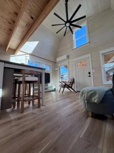 サンアントニオにあるModern Tiny Barn Urban Oasis in San Antonioの大きなリビングルーム(シーリングファン、テーブル付)