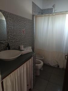 a bathroom with a sink and a toilet at Casa con jardín - Alquiler temporal en Monte in San Miguel del Monte +16 photos