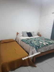 a bedroom with a bed with a blanket on it at Casa con jardín - Alquiler temporal en Monte in San Miguel del Monte