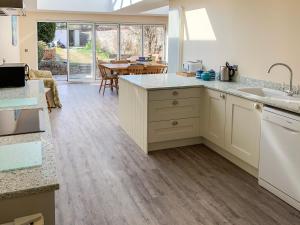 a kitchen with white cabinets and a dining room at Ron's House in Broadstairs