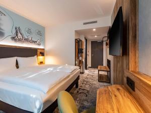 Una cama o camas en una habitación de ibis Styles Hamburg Barmbek 90 fotos más