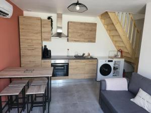 a kitchen and living room with a table and a couch at Le terracotta in La Vernelle