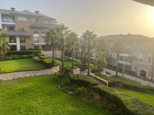 a view of a yard with palm trees and a building at Beach appartement in Kenitra