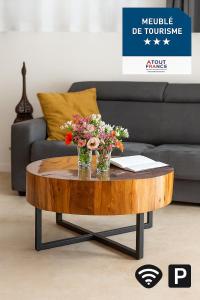 a coffee table with flowers on it in front of a couch at Nature&détente au pied du Mont Ventoux parking privé gratuit in Carpentras