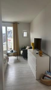 a living room with a couch and a tv at NOUVEAU AU COEUR DES CORDIERS ! QUARTIER HISTORIQUE in Le Tréport