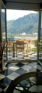 Ein Tisch und Stühle auf einem Balkon mit Aussicht in der Unterkunft Apartment Vujosevic D&D in Kotor
