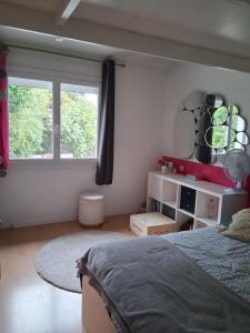 a bedroom with a bed and a large window at Escale fleurie in Toulouse