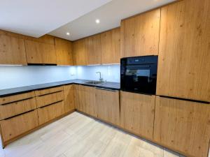 a kitchen with wooden cabinets and a microwave at Ferienwohnung Rosenburg in Randa