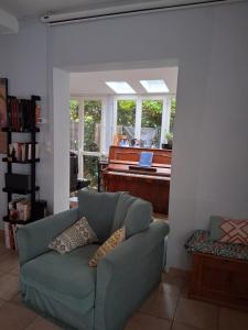 ein Wohnzimmer mit einer Couch und einem Klavier in der Unterkunft Escale fleurie in Toulouse + 25 Fotos
