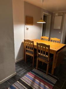 a wooden dining room table with four chairs and a light at Strand huset in Hitra +14 photos