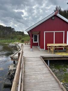 a red building with a picnic table on a dock at Strand huset in Hitra