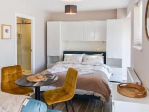 een slaapkamer met een bed, een tafel en stoelen bij Oak - Uk50462 in Alvington