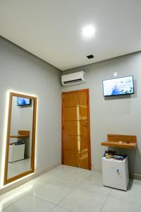 a room with a door and a television on the wall at Pousada Malibu in Vitória da Conquista
