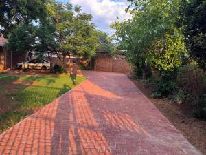 a man walking down a brick path in a yard at ORT Tranquil Stay in Boksburg
