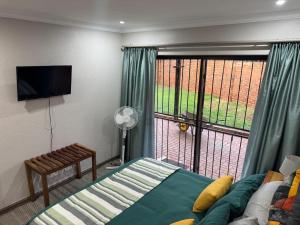 a bedroom with a bed and a large window at ORT Tranquil Stay in Boksburg