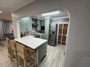 a kitchen with a white counter and a refrigerator at ORT Tranquil Stay in Boksburg