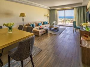 a living room with a couch and a table at Rixos Premium Magawish Suites and Villas- Ultra All-Inclusive in Hurghada +102 photos