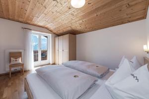 2 camas en un dormitorio con techo de madera en Schopplhof - panoramic apartments dolomites, en Villnoss